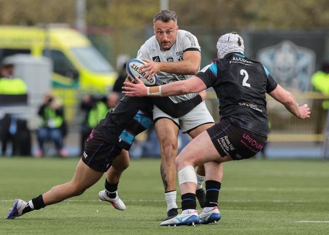 Toulon's French centre Jeremy Sinzelle (C) is tackled during the European Champions Cup rugby union quarter-final match between Glasgow Warriors and Toulon at Scotstoun Stadium in Glasgow, Scotland on April 11, 2026. (Photo by ROBERT PERRY / AFP)