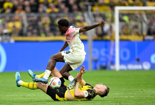 Bayer Leverkusen's Dutch forward #19 Ernest Poku (top) and Dortmund's German defender #04 Nico Schlotterbeck vie for the ball during the German first division Bundesliga football match between Borussia Dortmund and Bayer Leverkusen in Dortmund, western Germany, on April 11, 2026. (Photo by INA FASSBENDER / AFP) / DFL REGULATIONS PROHIBIT ANY USE OF PHOTOGRAPHS AS IMAGE SEQUENCES AND/OR QUASI-VIDEO