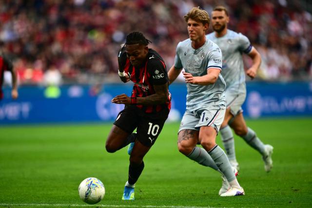 AC Milan's Portuguese forward #10 Rafael Leao (L) fights for the ball with Udinese's Danish defender #31 Thomas Kristensen (R) during the Italian Serie A football match between AC Milan and Udinese at the San Siro stadium in Milan on April 11, 2026. (Photo by MARCO BERTORELLO / AFP)