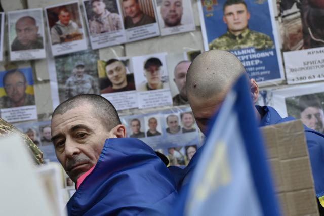 A released Ukrainian prisoner of war (POW) looks at portraits of missing or captured servicemen after being swapped in a prisoner exchange in the Chernihiv region on April 11, 2026, amid the Russian invasion of Ukraine. A truce between Russia and Ukraine to mark the Orthodox Easter entered into force on April 11, 2026, with Kyiv warning it would respond "immediately" if Russia violated it. The warring sides exchanged 175 prisoners of war each, both countries said, in one of their few areas of cooperation. (Photo by Genya SAVILOV / AFP)