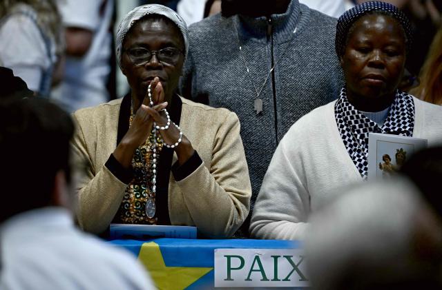 Faithfuls pray over a banner reading "Peace" as Pope Leo XIV presides over a prayer vigil and rosary for Peace in St. Peter's Basilica at the Vatican on April 11, 2026. (Photo by Filippo MONTEFORTE / AFP)