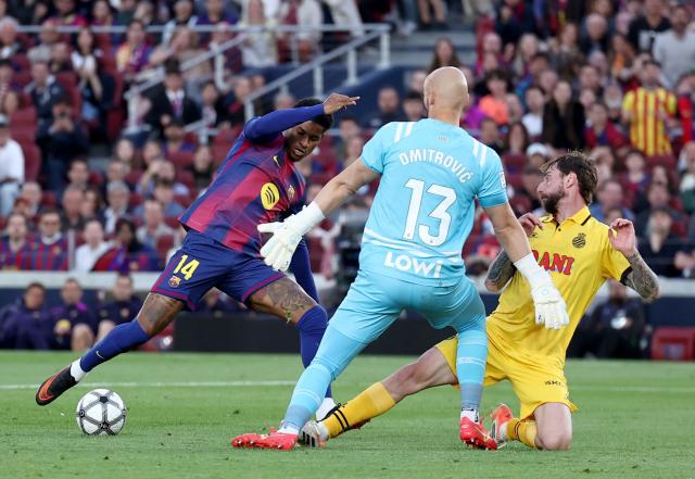 Barcelona's English forward #14 Marcus Rashford challenges Espanyol's Serbian goalkeeper #13 Marko Dmitrovic next to Espanyol's Spanish defender #05 Fernando Calero during the Spanish league football match between FC Barcelona and RCD Espanyol at the Camp Nou stadium in Barcelona on April 11 , 2026. (Photo by Josep LAGO / AFP)
