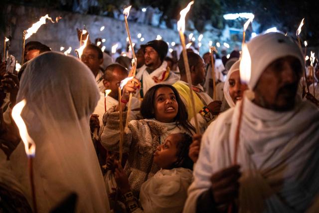Ethiopian Orthodox Christian followers hold up candles during their annual Holy Fire ceremony at Jerusalem’s Church of the Holy Sepulchre on April 11, 2026. The ceremony celebrated in the same way for 11 centuries, is marked by the appearance of "sacred fire" in the two cavities on either side of the Holy Sepulchre. (Photo by JOHN WESSELS / AFP)