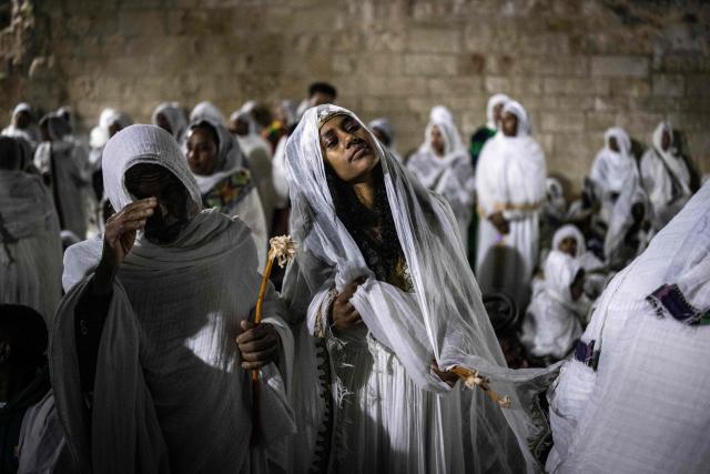TOPSHOT - An Ethiopian Orthodox Christian worshipper adjusts her headscarf during the annual Holy Fire ceremony at Jerusalem’s Church of the Holy Sepulchre on April 11, 2026. The ceremony celebrated in the same way for 11 centuries, is marked by the appearance of "sacred fire" in the two cavities on either side of the Holy Sepulchre. (Photo by JOHN WESSELS / AFP)