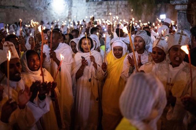 Ethiopian Orthodox Christian followers hold up candles during their annual Holy Fire ceremony at Jerusalem’s Church of the Holy Sepulchre on April 11, 2026. The ceremony celebrated in the same way for 11 centuries, is marked by the appearance of "sacred fire" in the two cavities on either side of the Holy Sepulchre. (Photo by JOHN WESSELS / AFP)