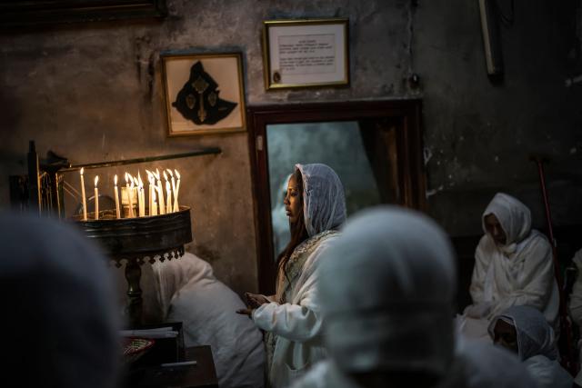 Followers of the Ethiopian Orthodox Church pray during the Holy Fire ceremony in Jerusalem’s Church of the Holy Sepulchre, on April 11, 2026. The ceremony celebrated in the same way for 11 centuries, is marked by the appearance of "sacred fire" in the two cavities on either side of the Holy Sepulchre. (Photo by MARCO LONGARI / AFP)