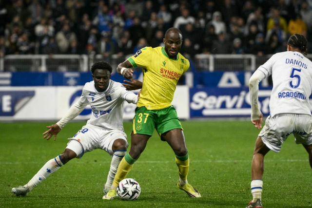 Nantes' Cameroonian forward #37 Ignatius Ganago (C) and Auxerre's French midfielder #08 Naouirou Ahamada (L) fight for the ball during the French L1 football match between AJ Auxerre and FC Nantes at the Stade de l'Abbe-Deschamps in Auxerre, central France, on April 11, 2026. (Photo by ARNAUD FINISTRE / AFP)