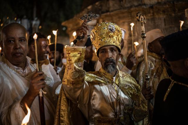 Archbishop of the Ethiopian Orthodox Church in Jerusalem, Abune Nathanael, bless faithfuls during the Holy Fire ceremony in Jerusalem’s Church of the Holy Sepulchre, on April 11, 2026. The ceremony celebrated in the same way for 11 centuries, is marked by the appearance of "sacred fire" in the two cavities on either side of the Holy Sepulchre. (Photo by MARCO LONGARI / AFP)