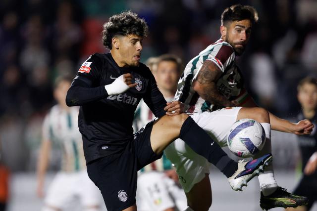 Sporting Lisbon's Uruguayan midfielder #20 Maximiliano Araujo fights for the ball with Estrela da Amadora's Brazilian forward #09 Rodrigo Pinho during the Portuguese League football match between CF Estrela da Amadora and Sporting CP at Jose Gomes stadium in Amadora  on April 11 , 2026. (Photo by FILIPE AMORIM / AFP)