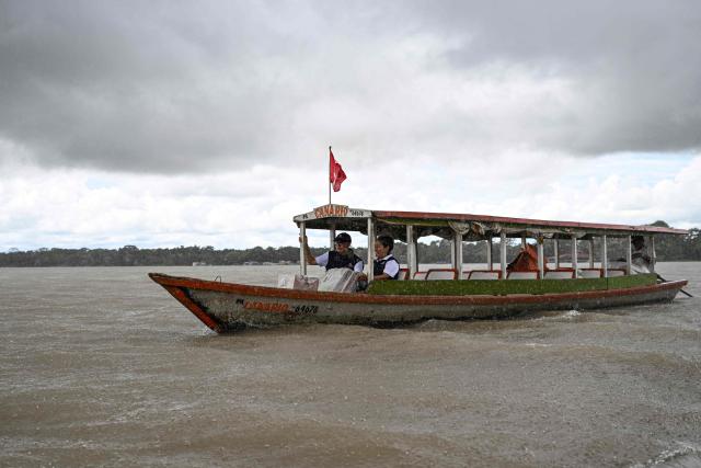 Workers of the National Office of Electoral Processes (ONPE) transport electoral material from the port of Pucallpa to hard-to-reach communities, traveling along the Ucayali River, in the department of Ucayali, in the central-eastern jungle of Peru, on April 11, 2026. Peru, which has had eight presidents in ten years, will hold general election on April 12, 2026, in which voters will have to choose among 35 candidates, including Keiko Fujimori, daughter of Peru's former president (1990-2000) Alberto Fujimori. (Photo by Hugo Alejos / AFP)