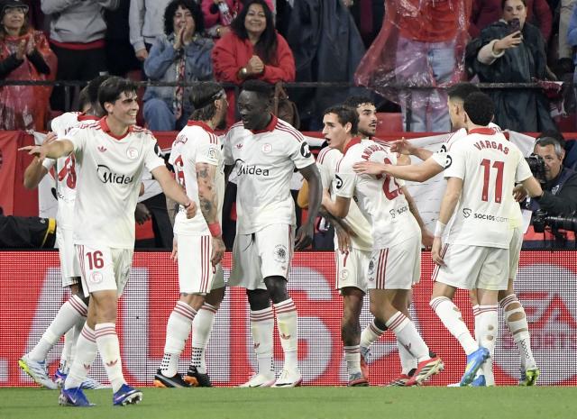 Sevilla's Serbian midfielder #06 Nemanja Gudelj (3L) celebrates with teammates scoring his team's second goal during the Spanish league football match between Sevilla FC and Club Atletico de Madrid at the Ramon Sanchez Pizjuan stadium in Seville on April 11 , 2026. (Photo by CRISTINA QUICLER / AFP)