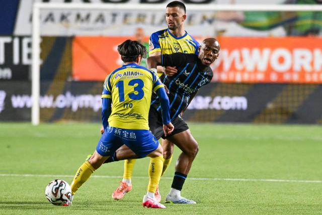 Club Brugge's Nigerian midfielder #15 Raphael Onyedika (C) fights for the ball with STVV's Japanese midfielder #13 Ryotaro Ito (L) and STVV's North Macedonian defender #26 Visar Musliu (R) during the Belgian "Pro League" champions' play-off (day 2 out of 10) football match between Sint-Truiden VV and Club Brugge at the Stayen Stadium in Sint-Truiden on April 11, 2026. (Photo by JILL DELSAUX / Belga / AFP) / Belgium OUT