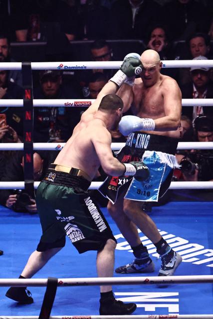 Britain's Tyson Fury (R) defends against Russia's Arslanbek Makhmudov (L) during their heavyweight 'Clash of the Giants' contest at the Tottenham Hotspur stadium in London on April 11, 2026. (Photo by Henry NICHOLLS / AFP)