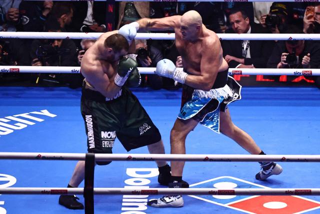 Britain's Tyson Fury (R) throws a punch at Russia's Arslanbek Makhmudov (L) during their heavyweight 'Clash of the Giants' contest at the Tottenham Hotspur stadium in London on April 11, 2026. (Photo by Henry NICHOLLS / AFP)