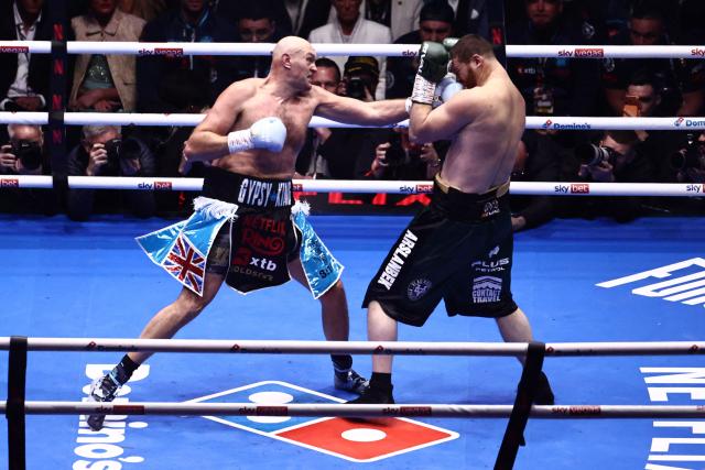Britain's Tyson Fury (L) throws a punch at Russia's Arslanbek Makhmudov (R) during their heavyweight 'Clash of the Giants' contest at the Tottenham Hotspur stadium in London on April 11, 2026. (Photo by Henry NICHOLLS / AFP)