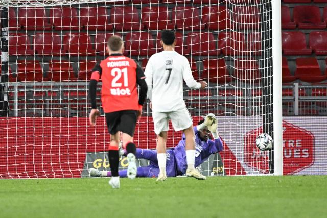 Rennes' French goalkeeper #30 Brice Samba (R) saves a penalty from Angers' Moroccan forward #7 Amine Sbai (C) during the French L1 football match between Rennes and Angers at Roazhon Park stadium in Rennes on April 11, 2026. (Photo by Sebastien Salom-Gomis / AFP)