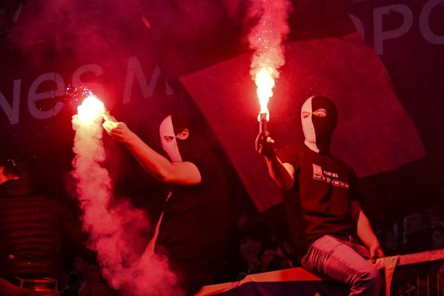 Angers supporters light flares during the French L1 football match between Rennes and Angers at Roazhon Park stadium in Rennes on April 11, 2026. (Photo by Sebastien Salom-Gomis / AFP)