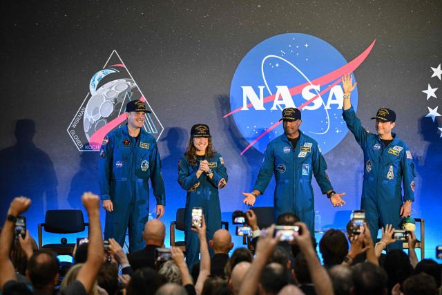 (L-R) NASA’s Artemis II mission astronauts Canadian Space Agency’s Jeremy Hansen, Christina Koch, Victor Glover and commander Reid Wiseman attend a welcoming ceremony at Ellington Field Joint Reserve Base in Houston, Texas, on April 11, 2026. An elated NASA late April 10 was celebrating its successful voyage around the Moon, after four astronauts safely returned to Earth having completed the first lunar flyby in more than 50 years. The NASA spacecraft carrying four astronauts -- three Americans and one Canadian -- splashed down without a hitch off the California coast, capping the US space agency's crewed test mission that returned with spectacular images of the Moon. (Photo by RONALDO SCHEMIDT / AFP)