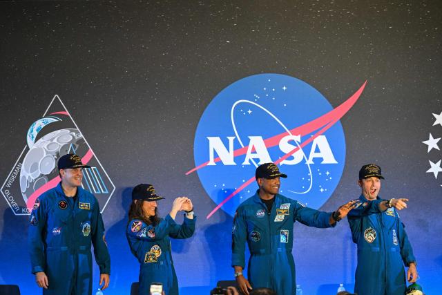 (L-R) NASA’s Artemis II mission astronauts Canadian Space Agency’s Jeremy Hansen, Christina Koch, Victor Glover and commander Reid Wiseman attend a welcoming ceremony at Ellington Field Joint Reserve Base in Houston, Texas, on April 11, 2026. An elated NASA late April 10 was celebrating its successful voyage around the Moon, after four astronauts safely returned to Earth having completed the first lunar flyby in more than 50 years. The NASA spacecraft carrying four astronauts -- three Americans and one Canadian -- splashed down without a hitch off the California coast, capping the US space agency's crewed test mission that returned with spectacular images of the Moon. (Photo by RONALDO SCHEMIDT / AFP)