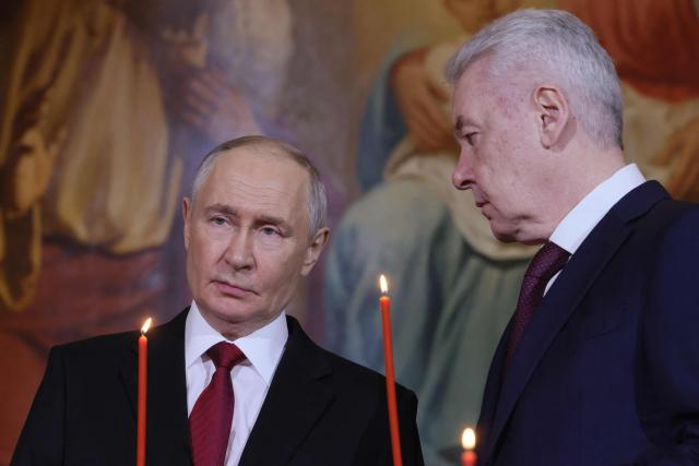In this pool photograph distributed by the Russian state agency Sputnik, Russia's President Vladimir Putin (L) and Moscow Mayor Sergey Sobyanin (R) attend the Orthodox Easter service at the Cathedral of Christ the Saviour in Moscow on April 12, 2026. (Photo by Mikhail METZEL / POOL / AFP)
