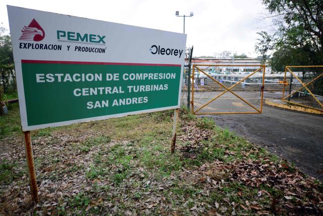 This image shows a sign marking a central turbine station belonging to Pemex in the community of San Andres, in Papantla, state of Veracruz on April 11, 2026. The Mexican government plans to extract natural gas using hydraulic fracturing, a method that has been criticized by environmental organizations, in order to reduce its dependence on imports from the United States, according to a plan presented by President Claudia Sheinbaum on April 9, 2026. (Photo by Marco Antonio MARTINEZ / AFP)