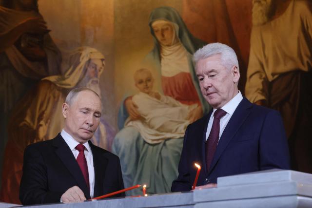 In this pool photograph distributed by the Russian state agency Sputnik, Russia's President Vladimir Putin (L) and Moscow Mayor Sergey Sobyanin (R) attend the Orthodox Easter service at the Cathedral of Christ the Saviour in Moscow on April 12, 2026. (Photo by Mikhail METZEL / POOL / AFP)