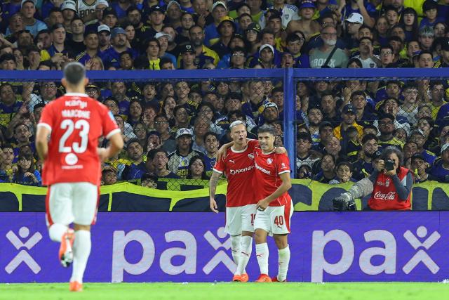 Independiente's Uruguayan forward #19 Matias Abaldo celebrates after scoring the opening goal with teammate midfielder #40 Victor Malcorra during the Argentine Professional Football League 2026 Apertura Tournament match between Boca Juniors and Independiente at La Bombonera Stadium in Buenos Aires on April 11, 2026. (Photo by Alejandro PAGNI / AFP)