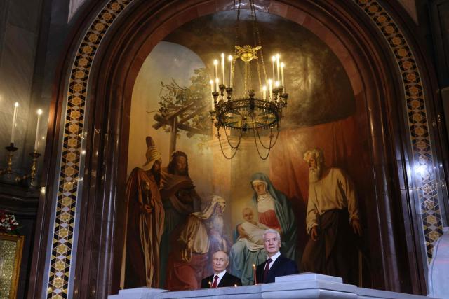 In this pool photograph distributed by the Russian state agency Sputnik, Russia's President Vladimir Putin (L) and Moscow Mayor Sergey Sobyanin (R) attend the Orthodox Easter service at the Cathedral of Christ the Saviour in Moscow on April 12, 2026. (Photo by Mikhail METZEL / POOL / AFP)
