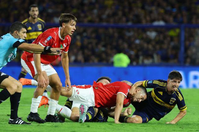 Boca Juniors' midfielder #30 Tomas Belmonte (R) and Independiente's midfielder #23 Ivan Marcone (C) fight for the ball during the Argentine Professional Football League 2026 Apertura Tournament match between Boca Juniors and Independiente at La Bombonera Stadium in Buenos Aires on April 11, 2026. (Photo by Alejandro PAGNI / AFP)