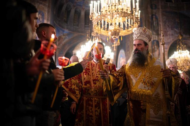 Bulgaria's Orthodox Church Patriarch Daniil (R) light candles during an Easter midnight mass in the golden-domed Alexander Nevski Cathedral in Sofia, Bulgaria, on April 11, 2026. (Photo by Nikolay DOYCHINOV / AFP)
