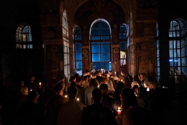 Orthodox believers hold candles as they take part in midnight Easter Service at the Gracanica medieval monastery near Pristina, Kosovo, on April 12, 2026. (Photo by Armend NIMANI / AFP)