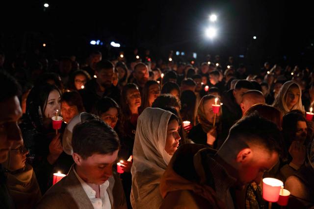 Orthodox believers hold candles as they takes part in midnight Easter Service at the Gracanica medieval monastery near Pristina, Kosovo, on April 12, 2026. (Photo by Armend NIMANI / AFP)