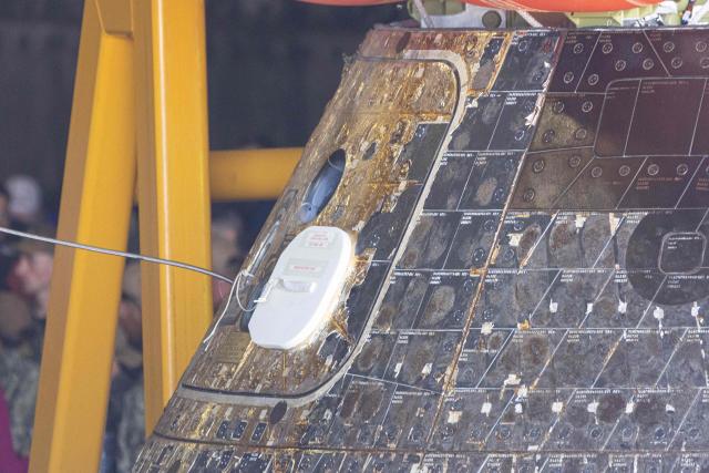The NASA ORION capsule named “Integrity” showing scarring burns from the heat of re-entry arrives in to the Port of San Diego in San Diego, California, on April 11, 2026. An elated NASA late April 10 was celebrating its successful voyage around the Moon, after four astronauts safely returned to Earth having completed the first lunar flyby in more than 50 years. The NASA spacecraft carrying four astronauts -- three Americans and one Canadian -- splashed down without a hitch off the California coast, capping the US space agency's crewed test mission that returned with spectacular images of the Moon. (Photo by Matt HARTMAN / AFP)