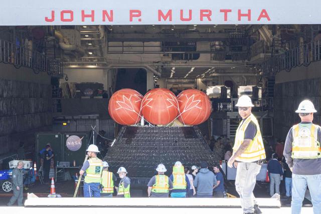 The NASA ORION capsule named “Integrity” showing scarring burns from the heat of re-entry arrives in to the Port of San Diego in San Diego, California, on April 11, 2026. An elated NASA late April 10 was celebrating its successful voyage around the Moon, after four astronauts safely returned to Earth having completed the first lunar flyby in more than 50 years. The NASA spacecraft carrying four astronauts -- three Americans and one Canadian -- splashed down without a hitch off the California coast, capping the US space agency's crewed test mission that returned with spectacular images of the Moon. (Photo by Matt HARTMAN / AFP)