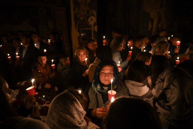 Orthodox believers hold candles as they take part in midnight Easter Service at the Gracanica medieval monastery near Pristina, Kosovo, on April 12, 2026. (Photo by Armend NIMANI / AFP)