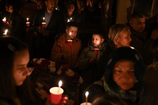 Orthodox believers hold candles as they take part in midnight Easter Service at the Gracanica medieval monastery near Pristina, Kosovo, on April 12, 2026. (Photo by Armend NIMANI / AFP)