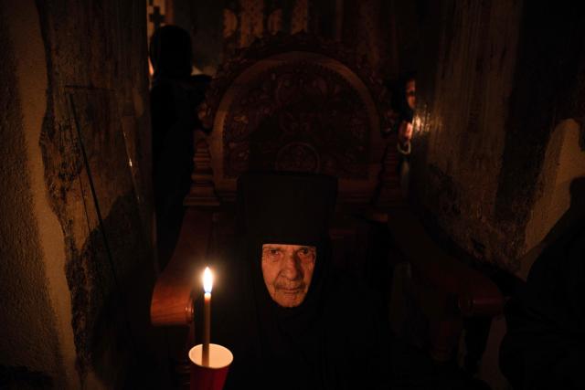 An Orthodox nun holds a candle as she takes part in midnight Easter Service at the Gracanica medieval monastery near Pristina, Kosovo, on April 12, 2026. (Photo by Armend NIMANI / AFP)