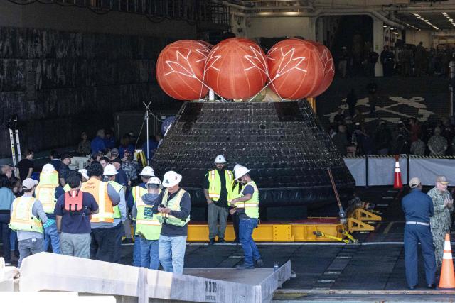 The NASA ORION capsule named “Integrity” showing scarring burns from the heat of re-entry arrives in to the Port of San Diego in San Diego, California, on April 11, 2026. An elated NASA late April 10 was celebrating its successful voyage around the Moon, after four astronauts safely returned to Earth having completed the first lunar flyby in more than 50 years. The NASA spacecraft carrying four astronauts -- three Americans and one Canadian -- splashed down without a hitch off the California coast, capping the US space agency's crewed test mission that returned with spectacular images of the Moon. (Photo by Matt HARTMAN / AFP)