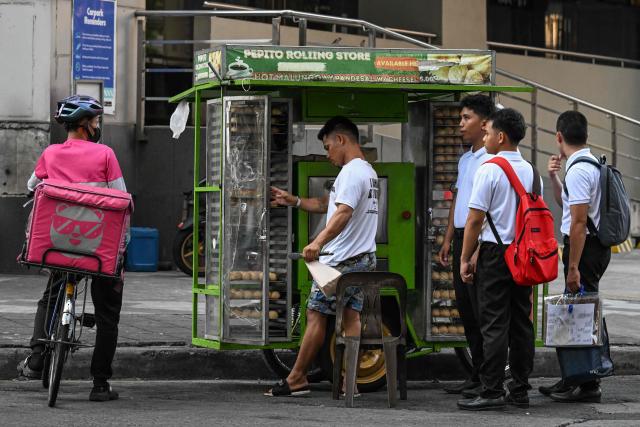 A man sells the popular breakfast roll 'pandesal' in Manila on April 7, 2026.lames in cooking to stay afloat. While sticker shock at petrol stations has garnered the biggest headlines since the war in the Middle East forced the partial closure of the Strait of Hormuz, the rising price of LPG has hit the import-dependent archipelago's humble street food vendors hard. (Photo by Jam STA ROSA / AFP) / TO GO WITH AFP STORY: Iran-War-US-Israel-Philippines-economy-LPG, by Pam CASTRO