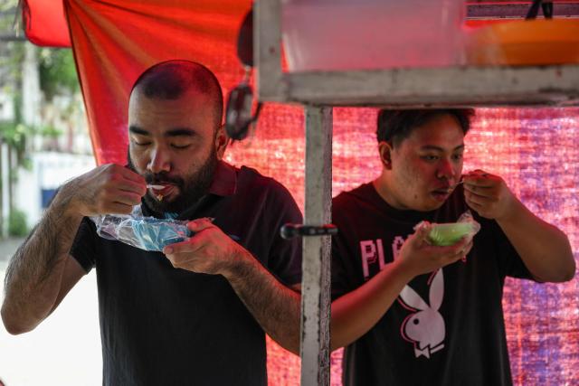 Men eat braised beef stew locally knows as 'pares' at a stall in Manila on April 7, 2026. While sticker shock at petrol stations has garnered the biggest headlines since the war in the Middle East forced the partial closure of the Strait of Hormuz, the rising price of LPG has hit the import-dependent archipelago's humble street food vendors hard. (Photo by Jam STA ROSA / AFP) / TO GO WITH AFP STORY: Iran-War-US-Israel-Philippines-economy-LPG, by Pam CASTRO