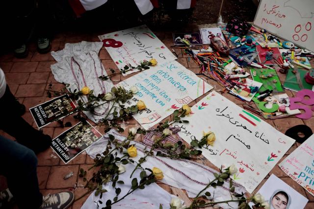 Flowers and signs are seen during a protest in support of Iran outside the Iranian embassy in Mexico City on April 11, 2026. (Photo by AFP)