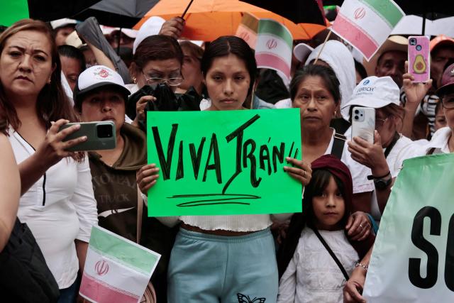 A demonstrator shows a sign that reads in Spanish, "Long live Iran" during a protest in favor of Iran outside the Iranian embassy in Mexico City on April 11, 2026. (Photo by AFP)