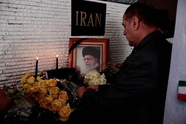 A demonstrator lays a wreath during a protest in support of Iran outside the Iranian embassy in Mexico City on April 11, 2026. (Photo by AFP)