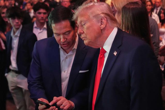 US President Donald Trump speaks with Secretary of State Marco Rubio at UFC 327: Jiri Prochazka vs Carlos Ulberg at Kaseya Center in Miami, on April 11, 2026. (Photo by Julia Demaree Nikhinson / POOL / AFP)