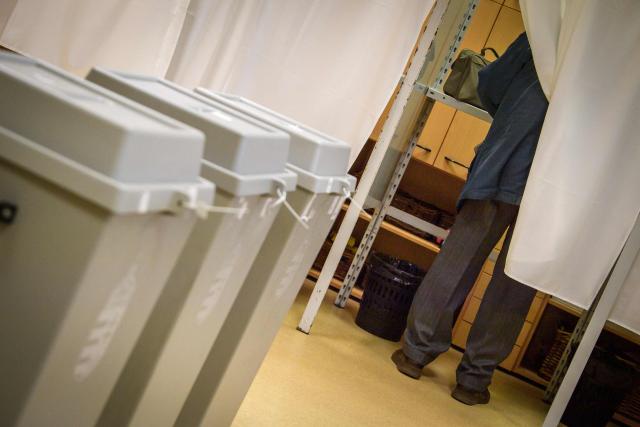 A voter fills out the ballot papers in a voting booth at a polling station in Budapest at the start of a general election in Hungary, on April 12, 2026. The vote could end Hungarian Prime Minister Viktor Orban's 16-year stint in power as the EU's longest serving current leader and a self-decribed "thorn" in the bloc's side. (Photo by Ferenc ISZA / AFP)