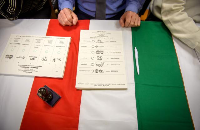 Ballot papers are placed on a Hungarian flag at a polling station in Budapest at the start of a general election in Hungary, on April 12, 2026. The vote could end Hungarian Prime Minister Viktor Orban's 16-year stint in power as the EU's longest serving current leader and a self-decribed "thorn" in the bloc's side. (Photo by Ferenc ISZA / AFP)