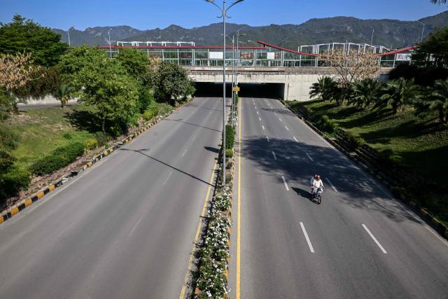 A motorcyclist rides along a deserted road after authorities restricted movement for the US-Iran peace talks in Islamabad on April 12, 2026. Iran and the United States failed to reach an agreement to end the war in the Middle East, US Vice President JD Vance said on April 12 after marathon talks in Islamabad, adding that he was leaving negotiations after giving Tehran the "final and best offer". (Photo by Farooq NAEEM / AFP)