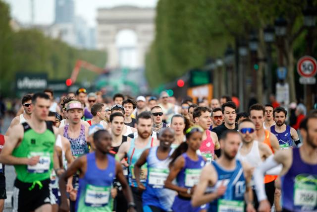 Athletes take the start on the Champs-Elysees avenue during the Paris Marathon, with the Arc de Triomphe in the background, in Paris, on April 12, 2026. (Photo by Ian LANGSDON / AFP)
