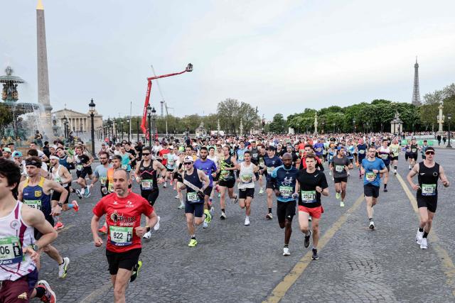 Atheletes run past the Place de la Concorde, with the National Assembly (L) and the Eiffel Tower in the background, during the Paris Marathon, in Paris, on April 12, 2026. (Photo by STEPHANE DE SAKUTIN / AFP)
