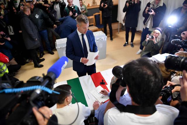 Peter Magyar (C), leader of the pro-European conservative TISZA party, gets his ballot papers at a polling station set up in a kindergarten in Budapest during a general election in Hungary, on April 12, 2026. The vote could end Hungarian Prime Minister Viktor Orban's 16-year stint in power as the EU's longest serving current leader and a self-decribed "thorn" in the bloc's side. (Photo by Ferenc ISZA / AFP)